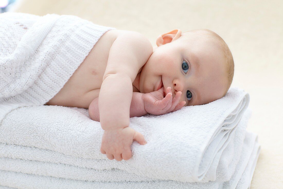 Baby boy lying on towels