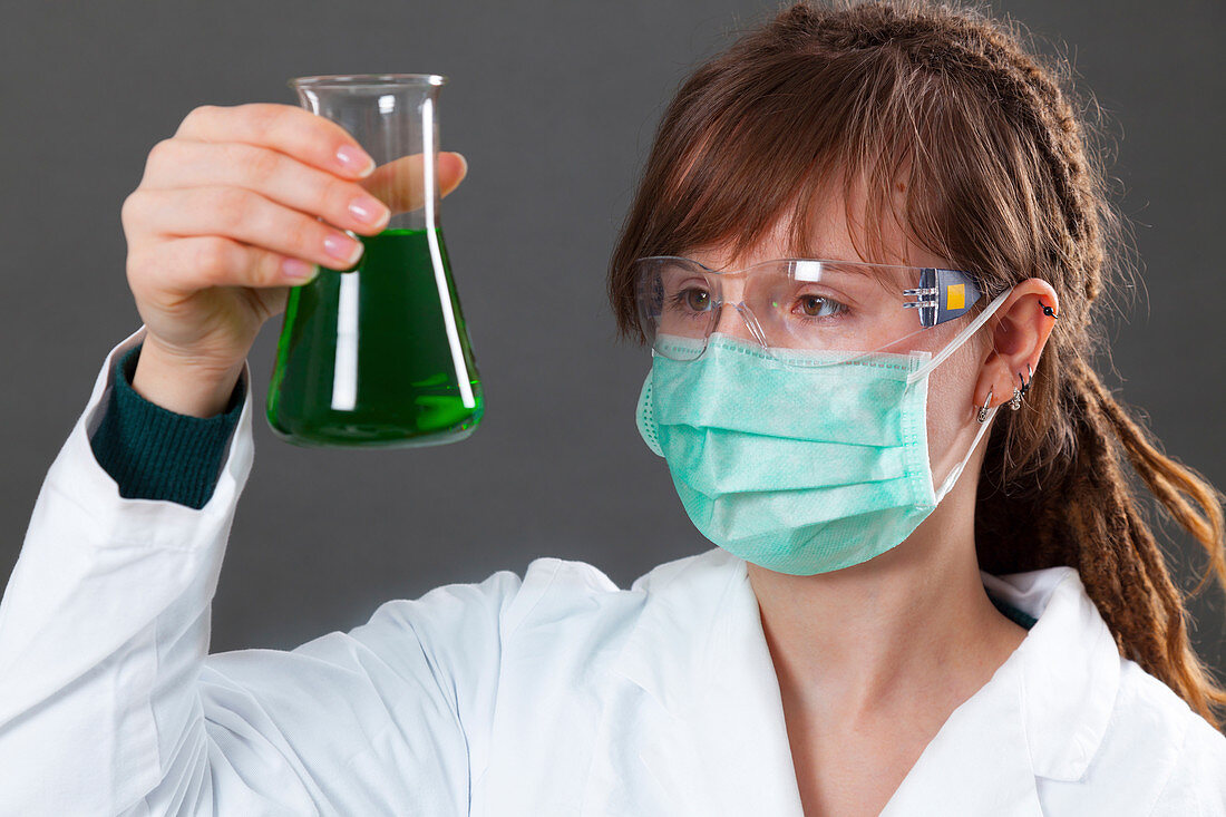 Young woman holding a conical flask