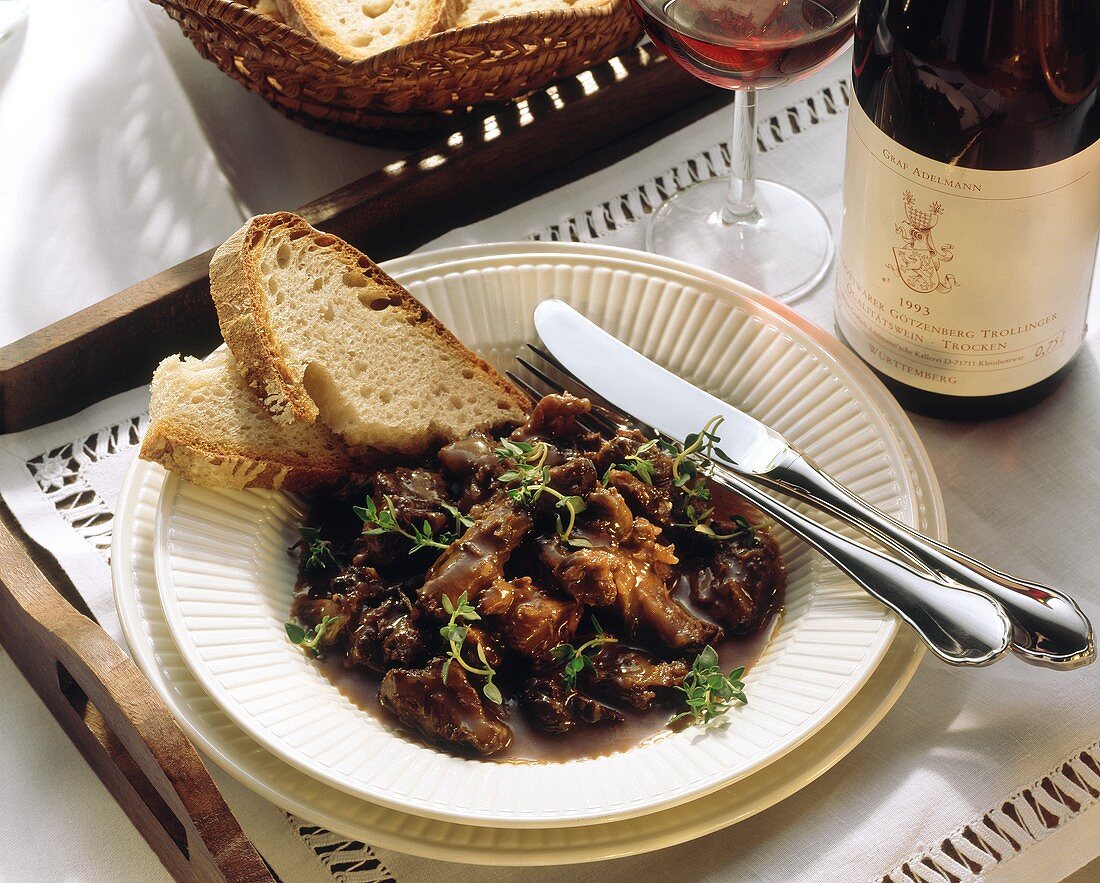 Ochsenschwanzragout mit Thymian, Deko: Weißbrot, Rotwein