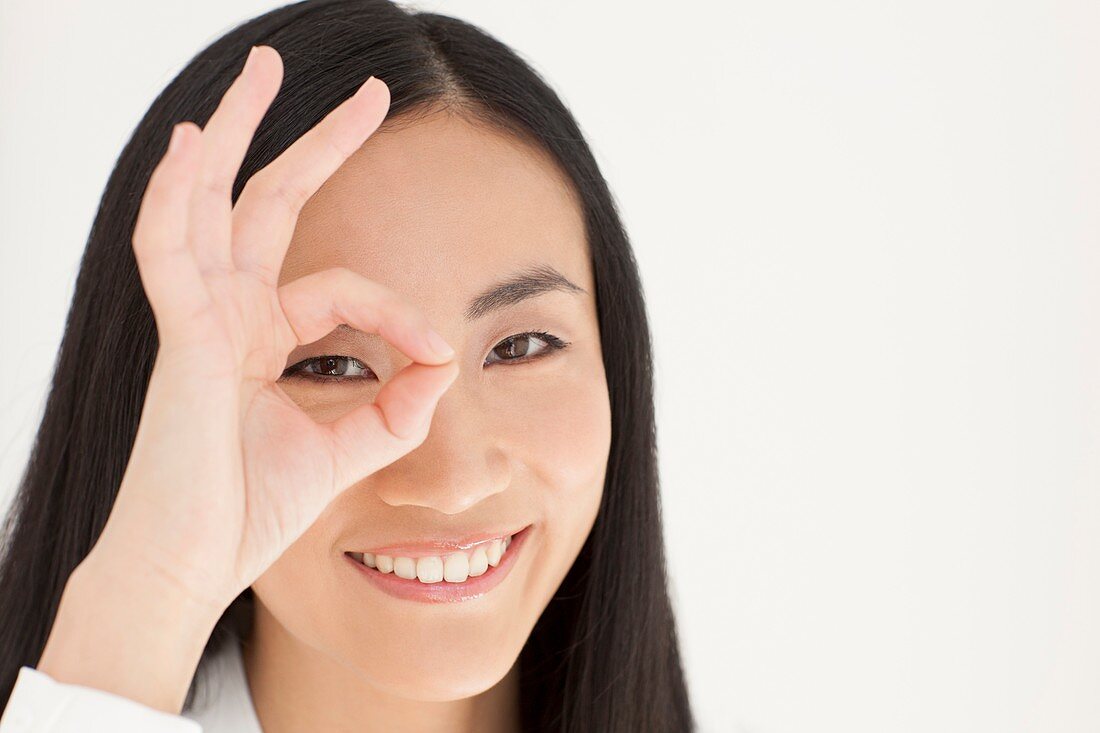 Woman looking through fingers