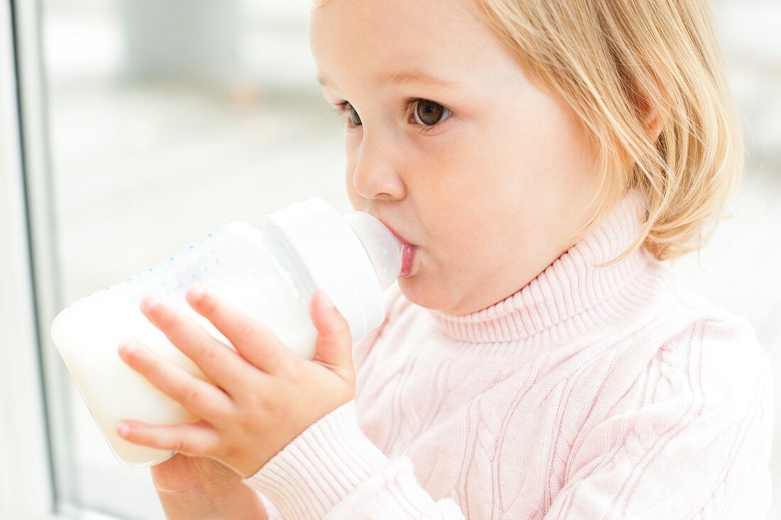 Toddler holding a bottle of milk