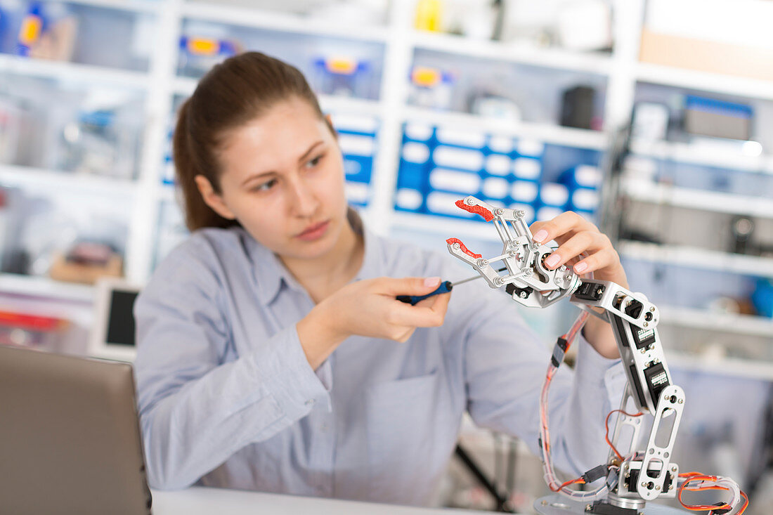 Student repairing robotic equipment