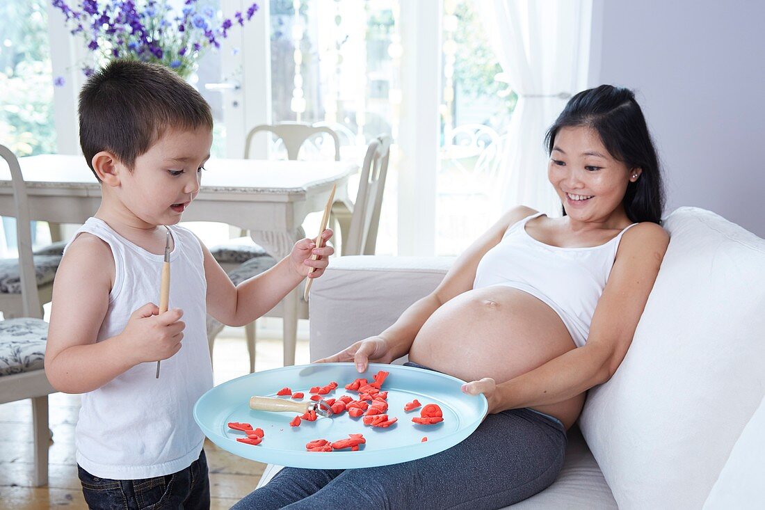 Pregnant woman playing with son