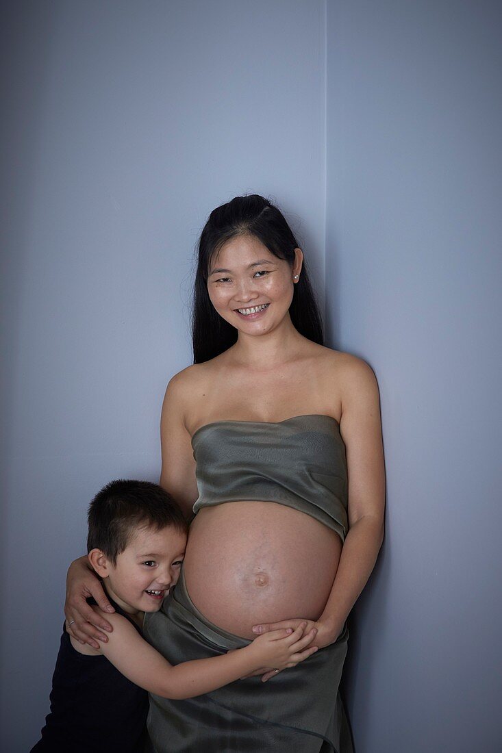 Pregnant woman with arm around her son