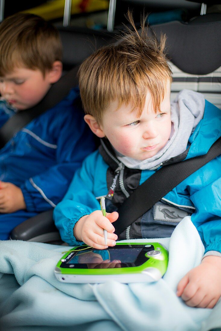 Boy in car with a digital device