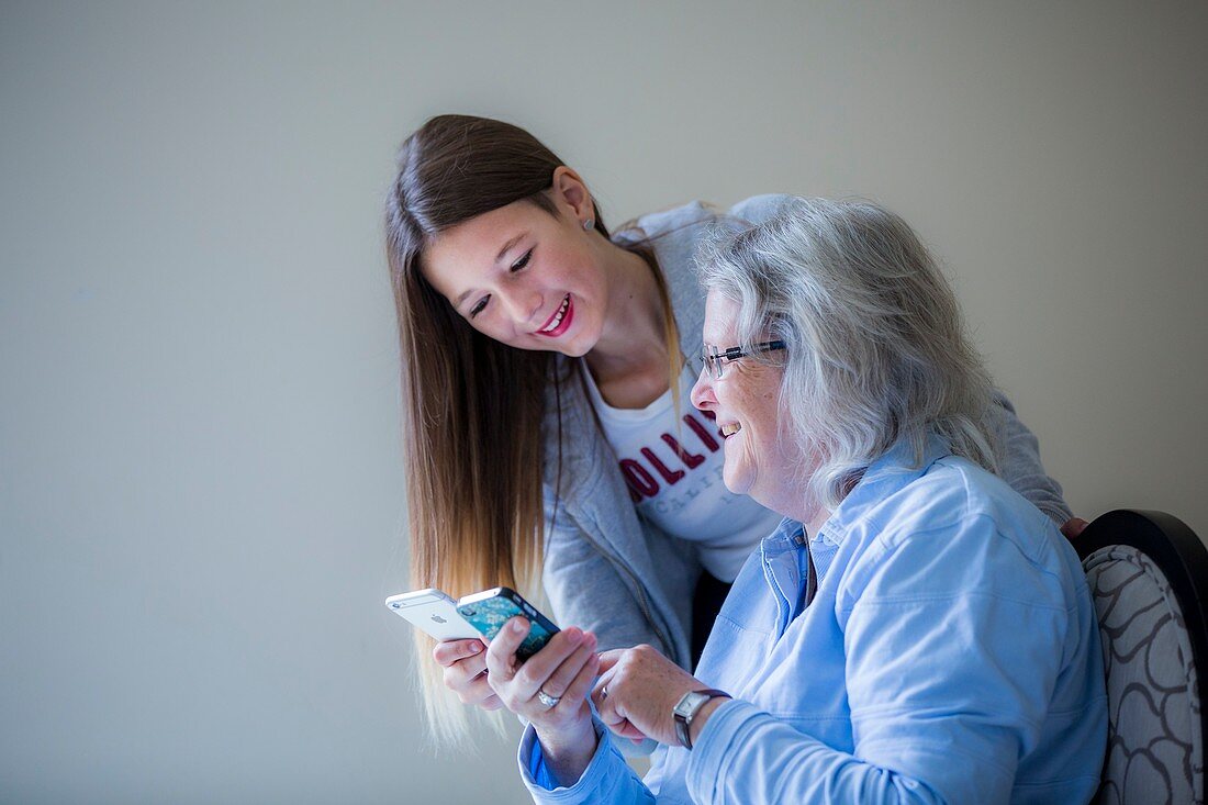 Girl showing grandmother smartphone