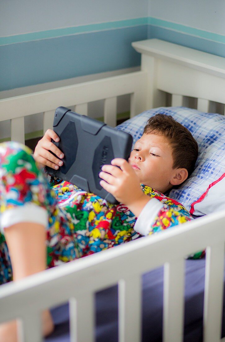 Boy in bed using a digital tablet