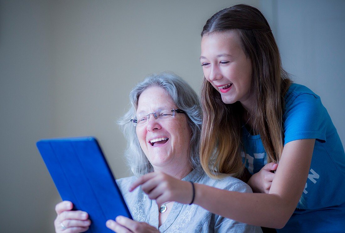 Girl and grandmother using tablet