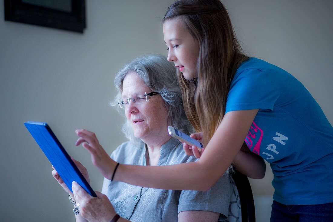 Girl and grandmother using tablet