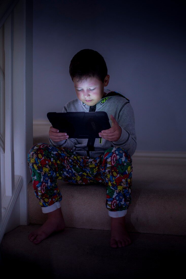 Boy using a digital tablet in the dark