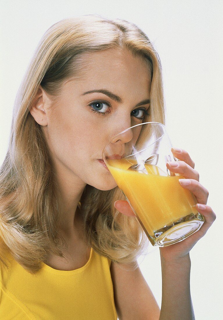 Blonde Frau trinkt Orangensaft