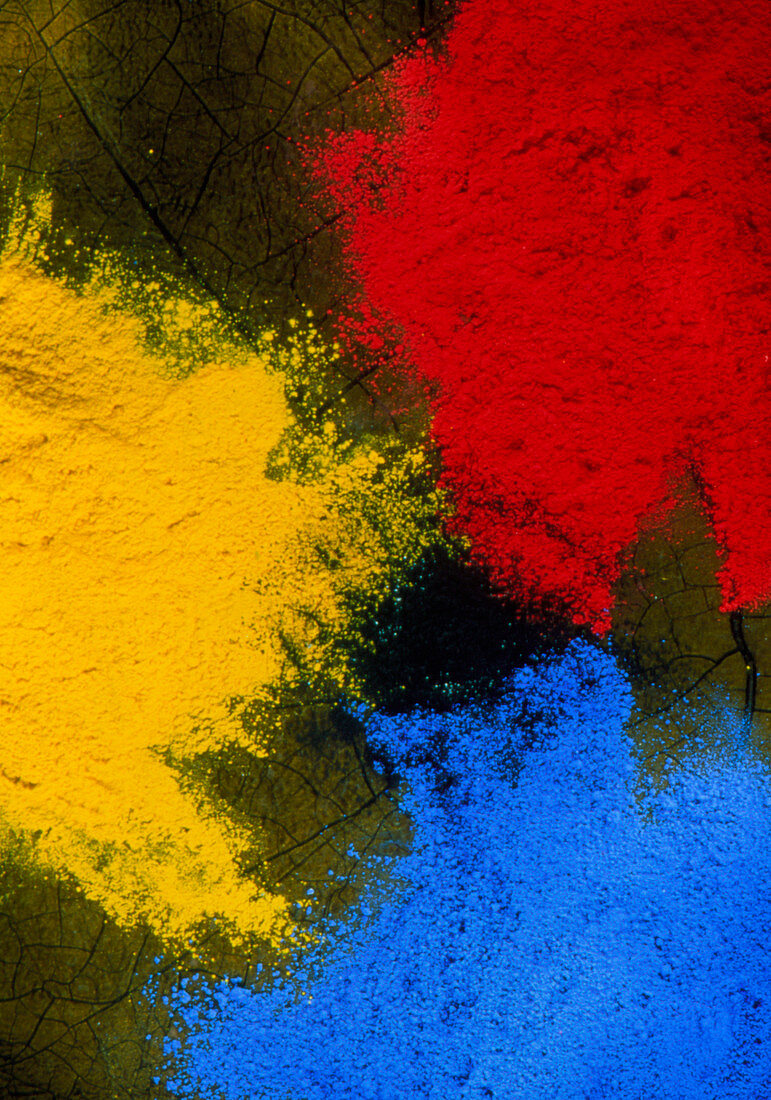 Three piles of powder paint in primary colours