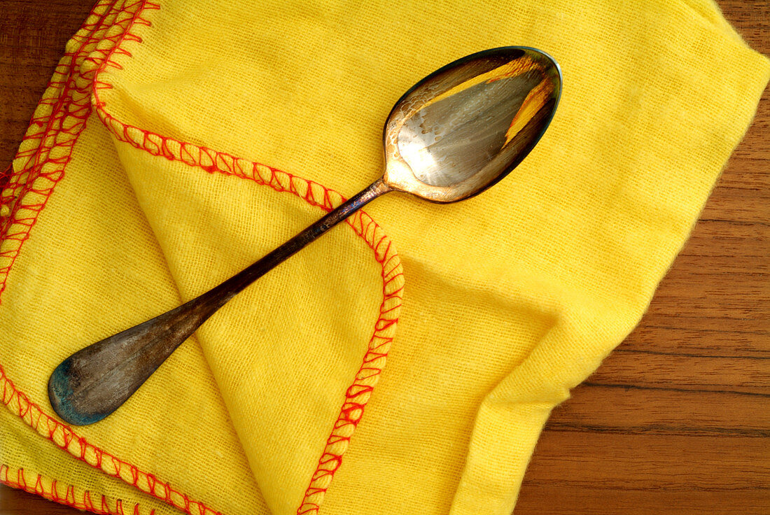Silver spoon and polishing cloth