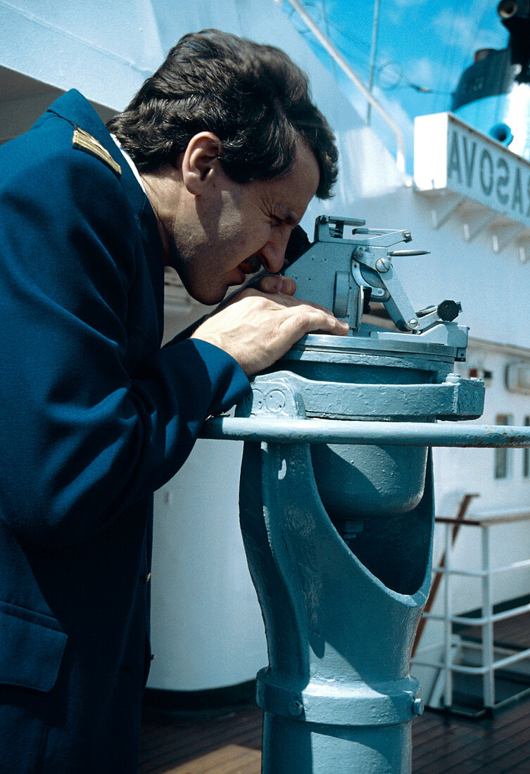 Ship's navigation officer takes a compass bearing