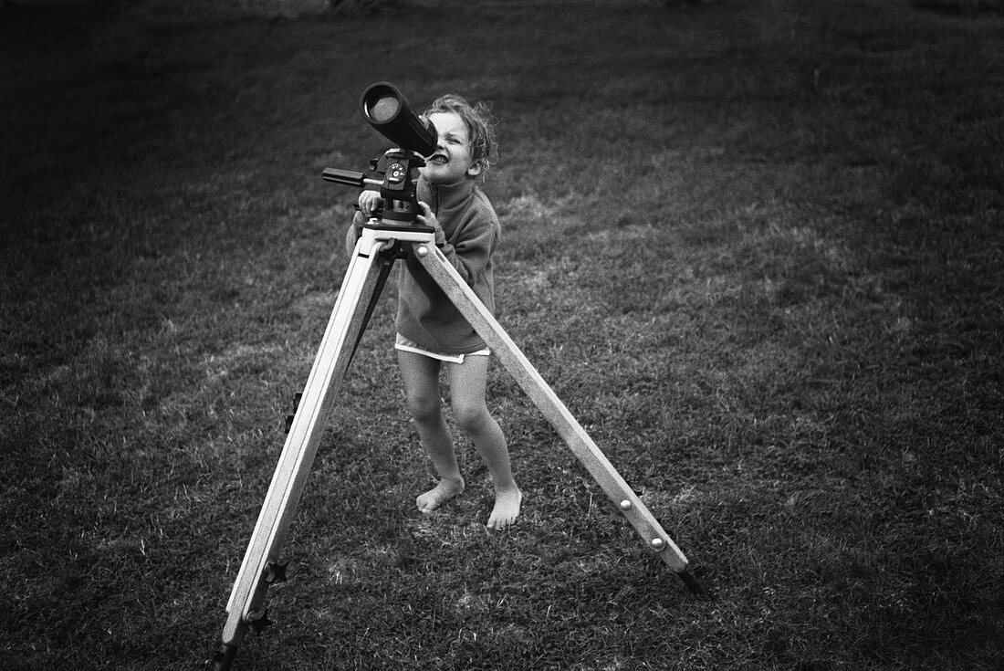 Young girl using a telescope