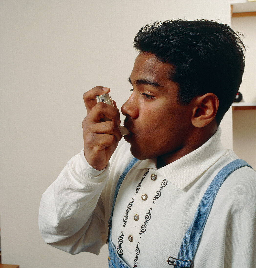 Teenage boy using asthma inhaler