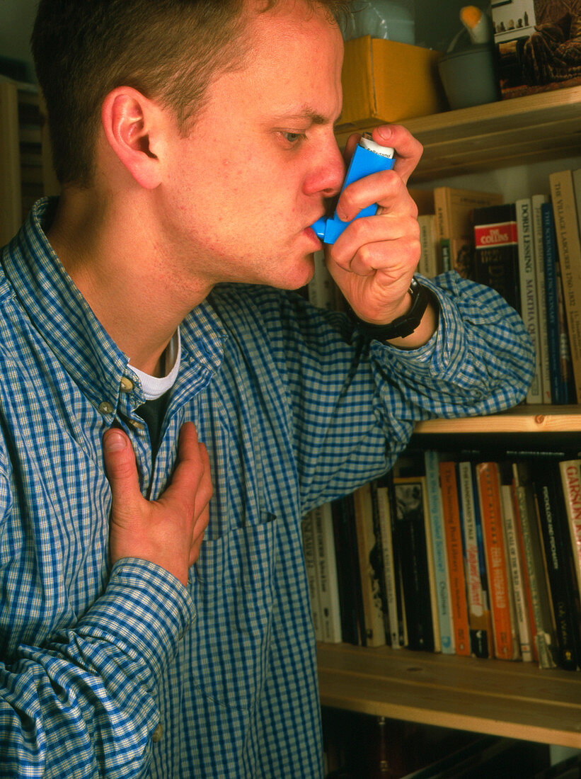 Young man using an aerosol inhaler for asthma