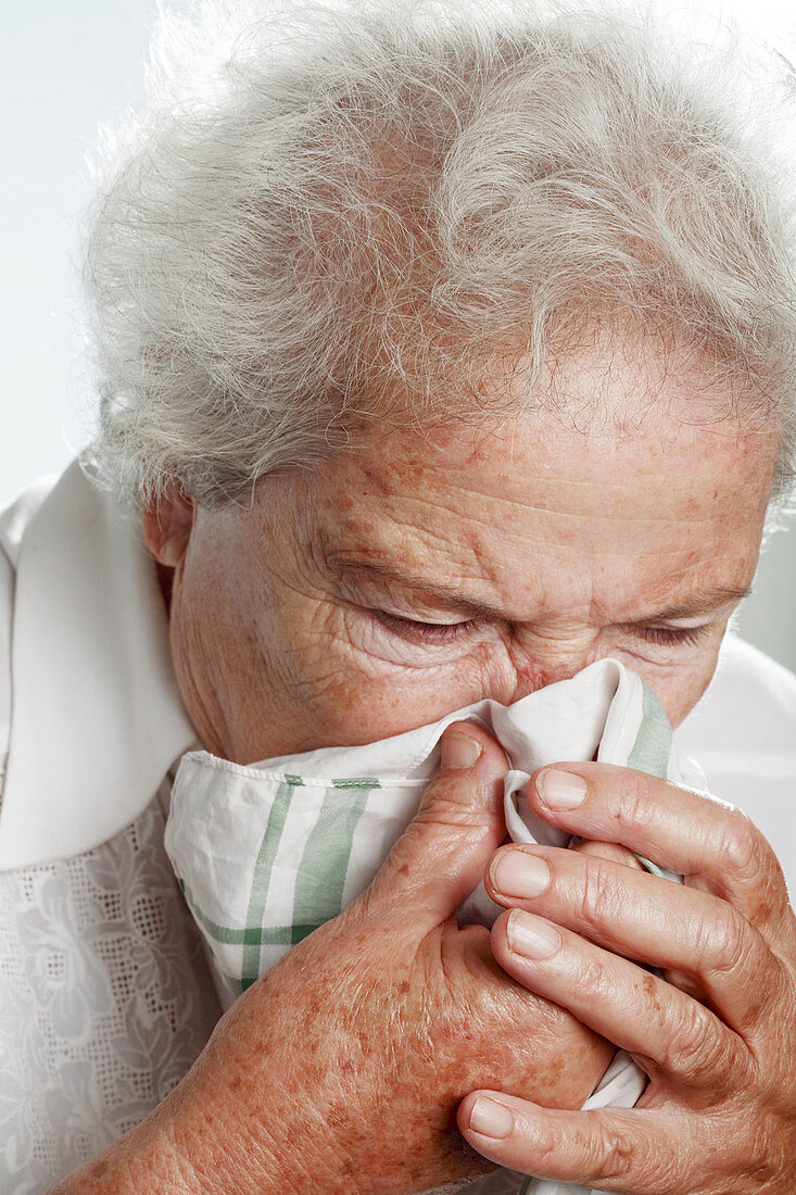 Elderly woman sneezing