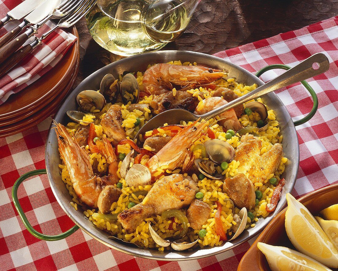 Paella with meat and seafood in pan