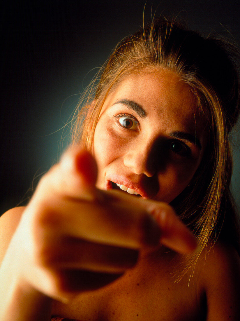 Teenage girl points finger in anger or frustration