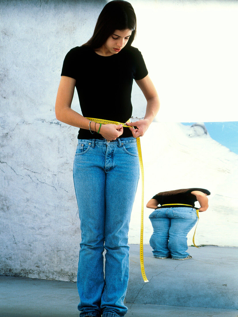 Anorexic teenage girl measuring herself with tape
