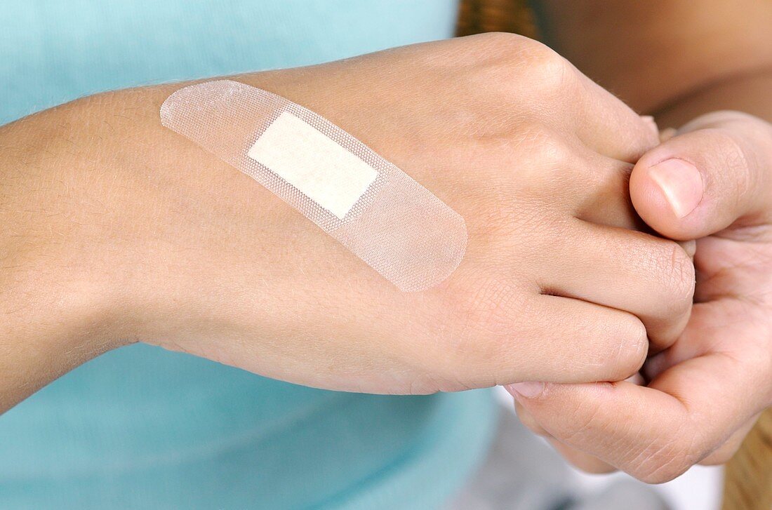 Woman applying a sticking plaster