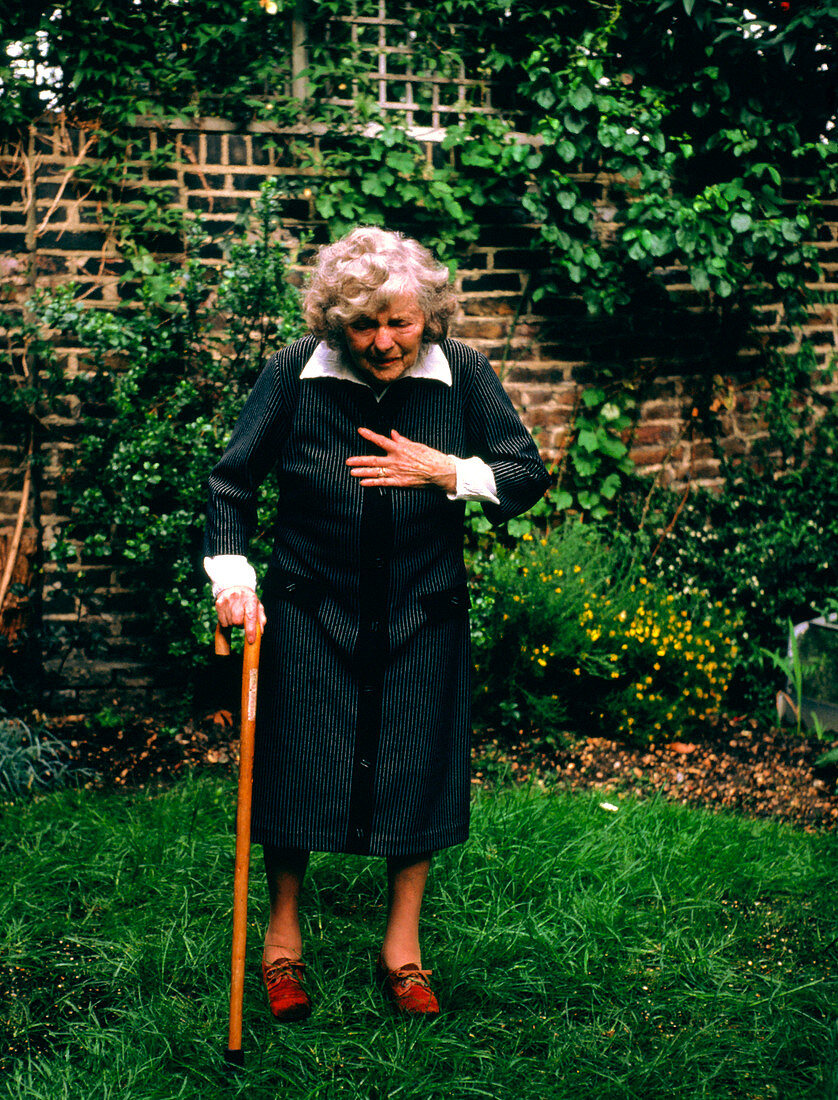 Elderly woman experiencing chest pains in garden