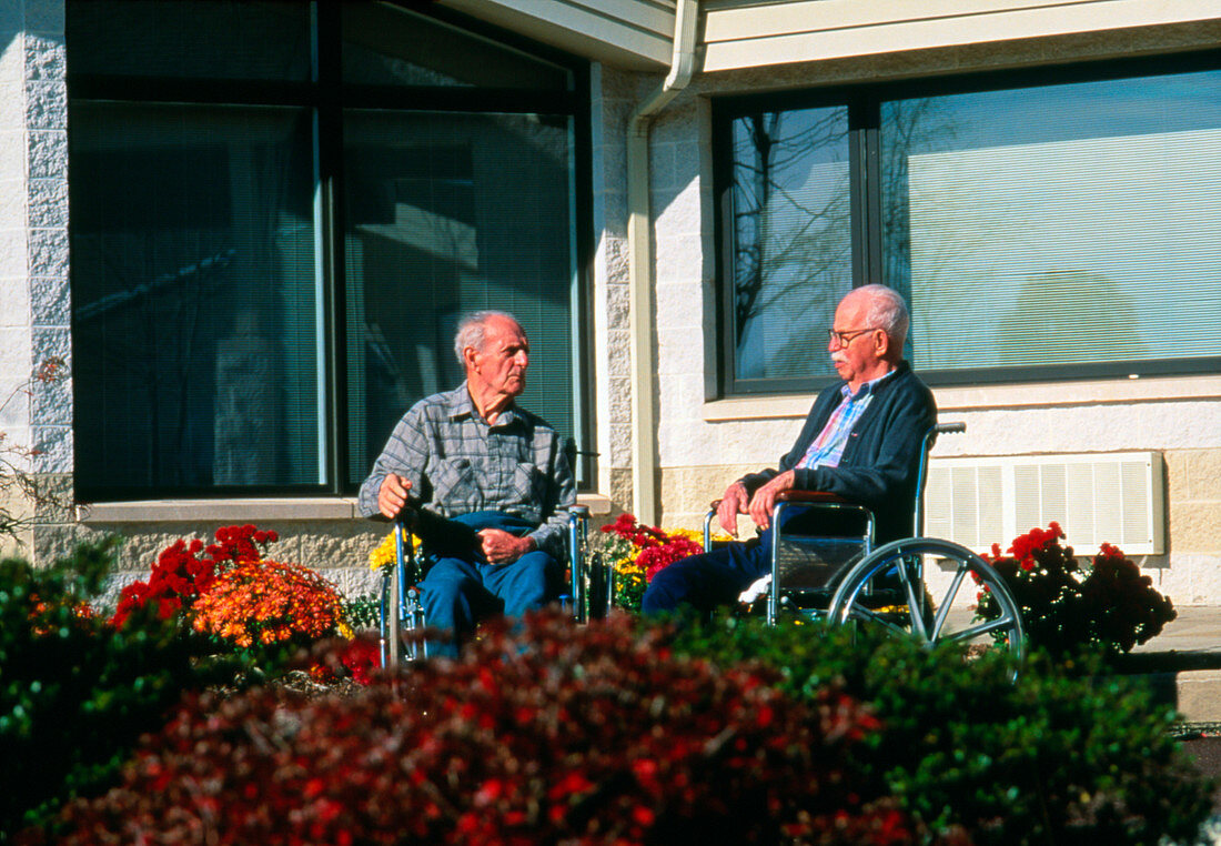 Elderly men in wheelchairs outside nursing home