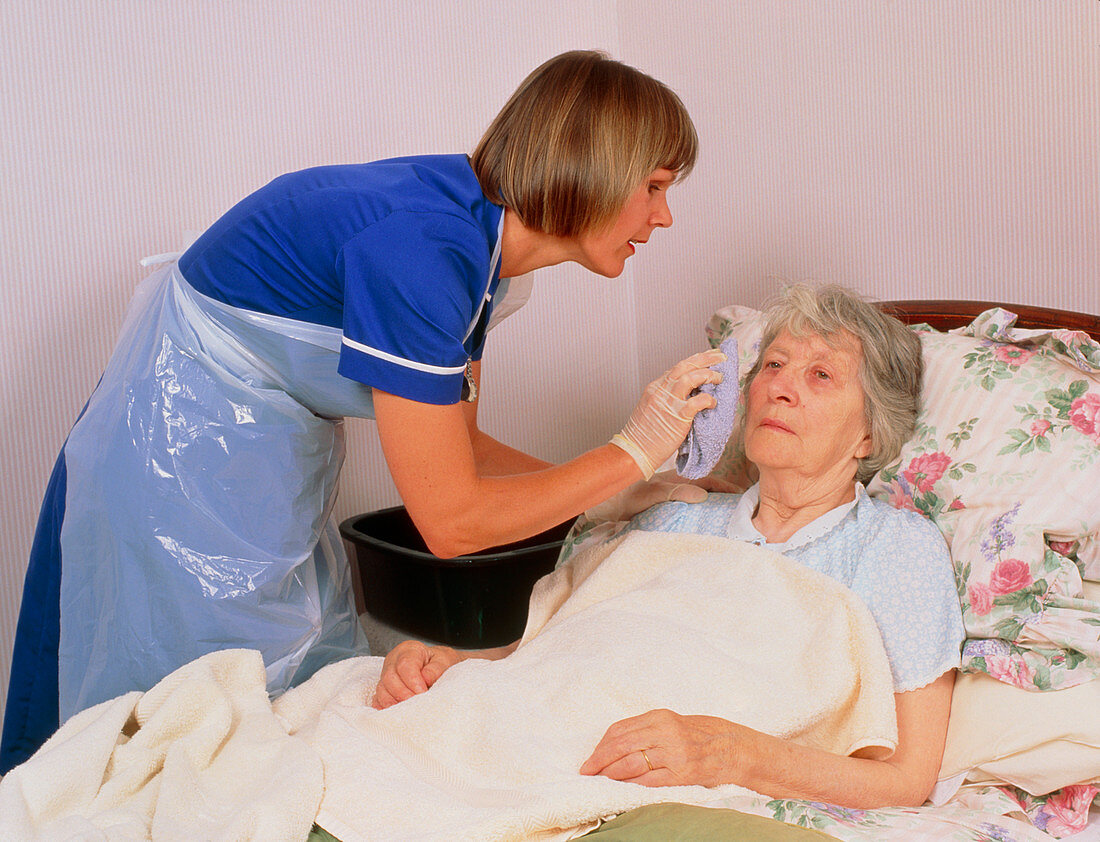 District nurse gives elderly patient a bed bath