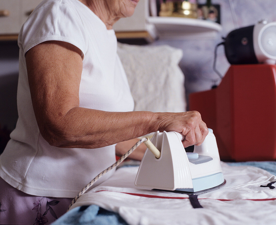 Elderly woman ironing