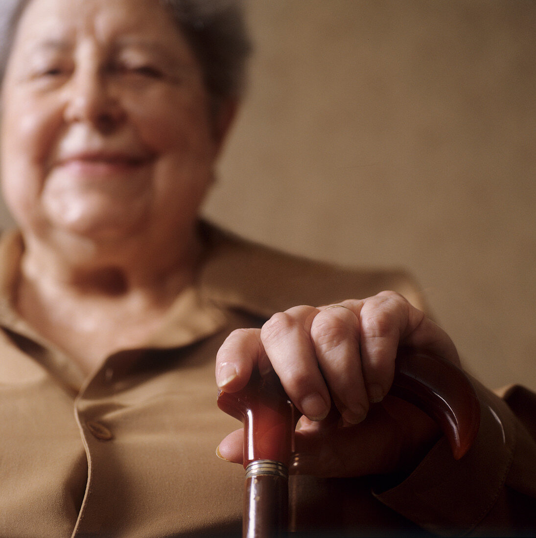 Elderly woman clasping a walking stick