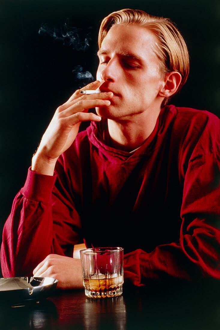 Young man smoking and drinking