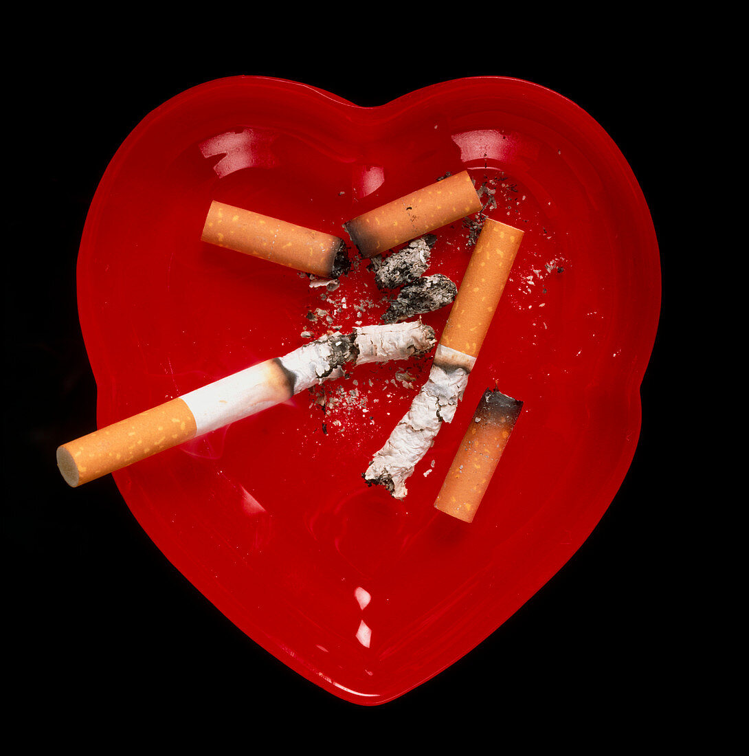 Cigarette butts in red heart-shaped ash tray