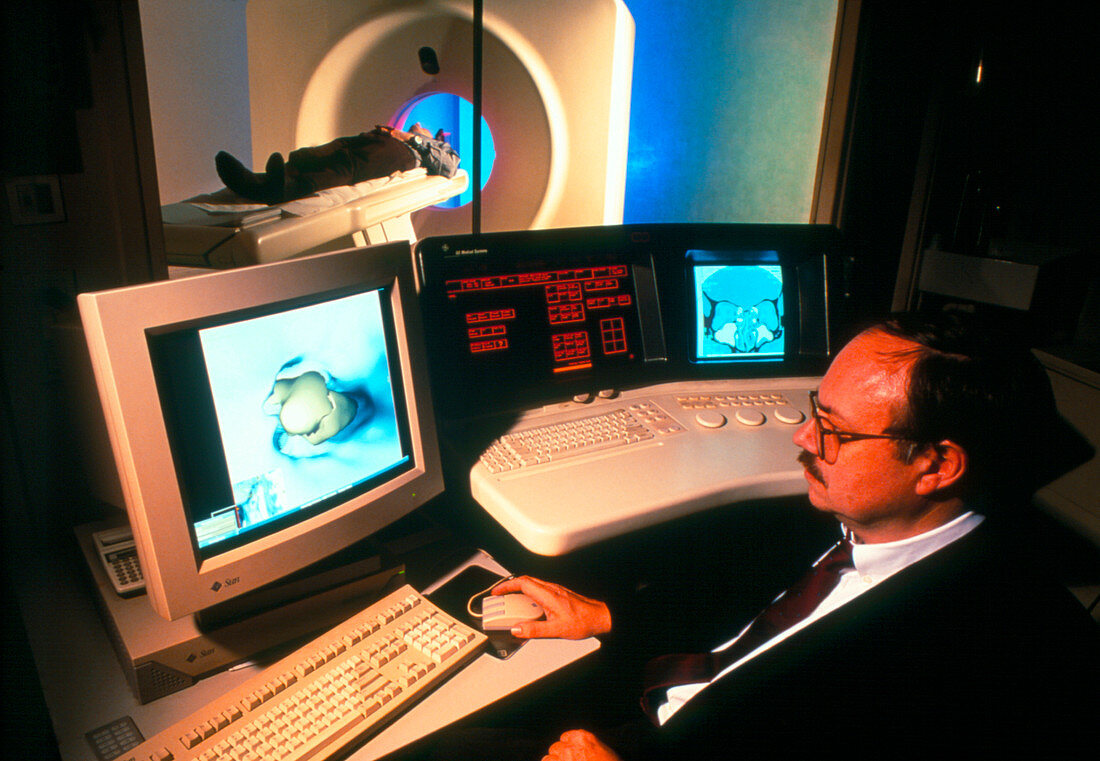 Doctor monitoring patient undergoing CT scan