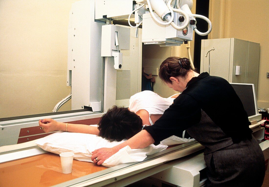 Woman undergoing an abdominal X-ray examination