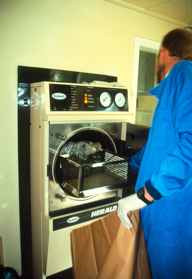 Medical technician operating a hospital autoclave