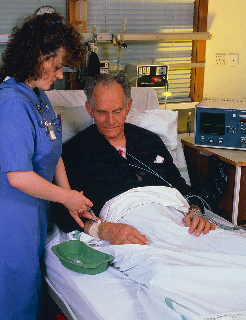 Nurse giving injection to coronary care patient