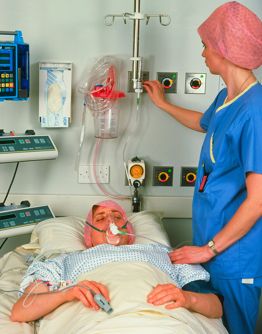 Woman with oxygen mask in post-op recovery room