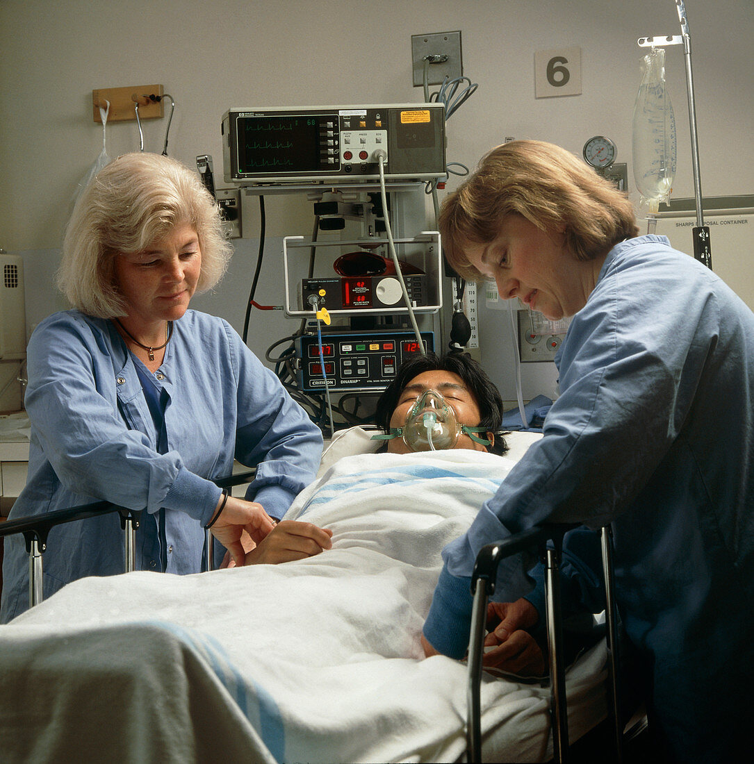 Female nurses monitor a patient after surgery
