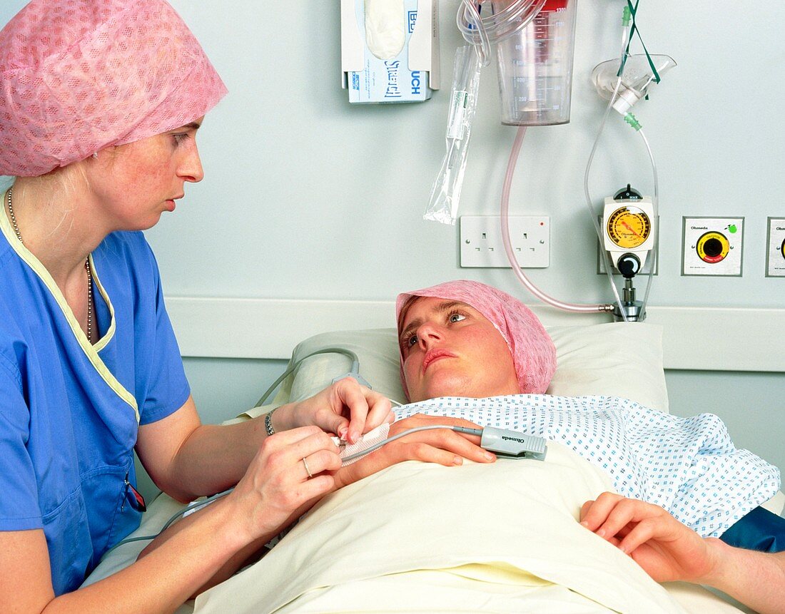 Nurse preparing female patient for operation