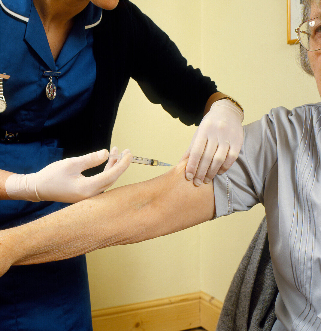 Elderly woman given injection by district nurse