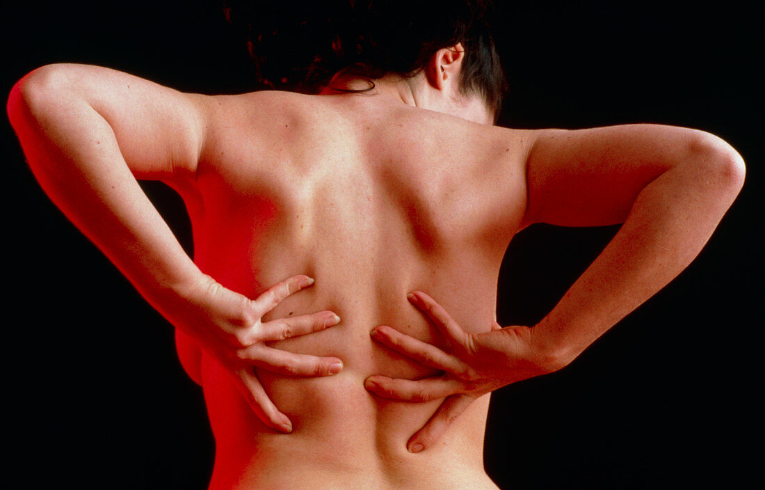 Woman suffering from back pain doing self-massage