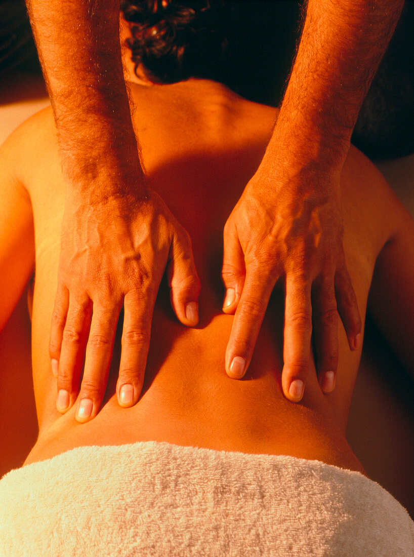 Woman being given a back massage by male masseur