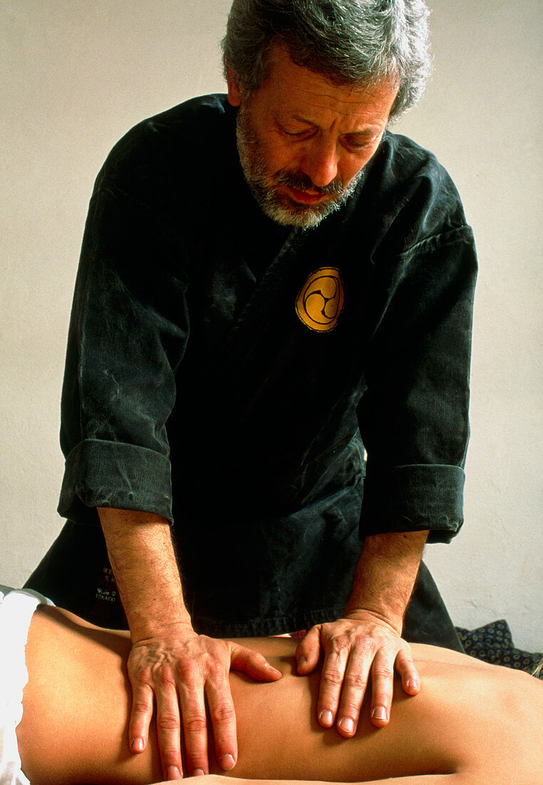 Man carrying out shiatsu massage on a woman's back