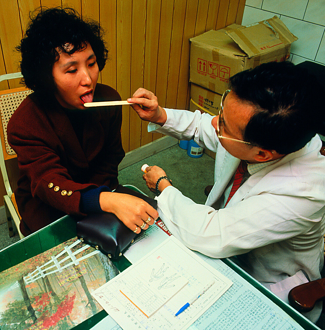 Woman having tongue examination by Chinese doctor