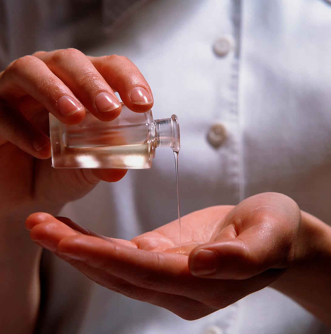 Aromatherapy oil being poured into a cupped hand