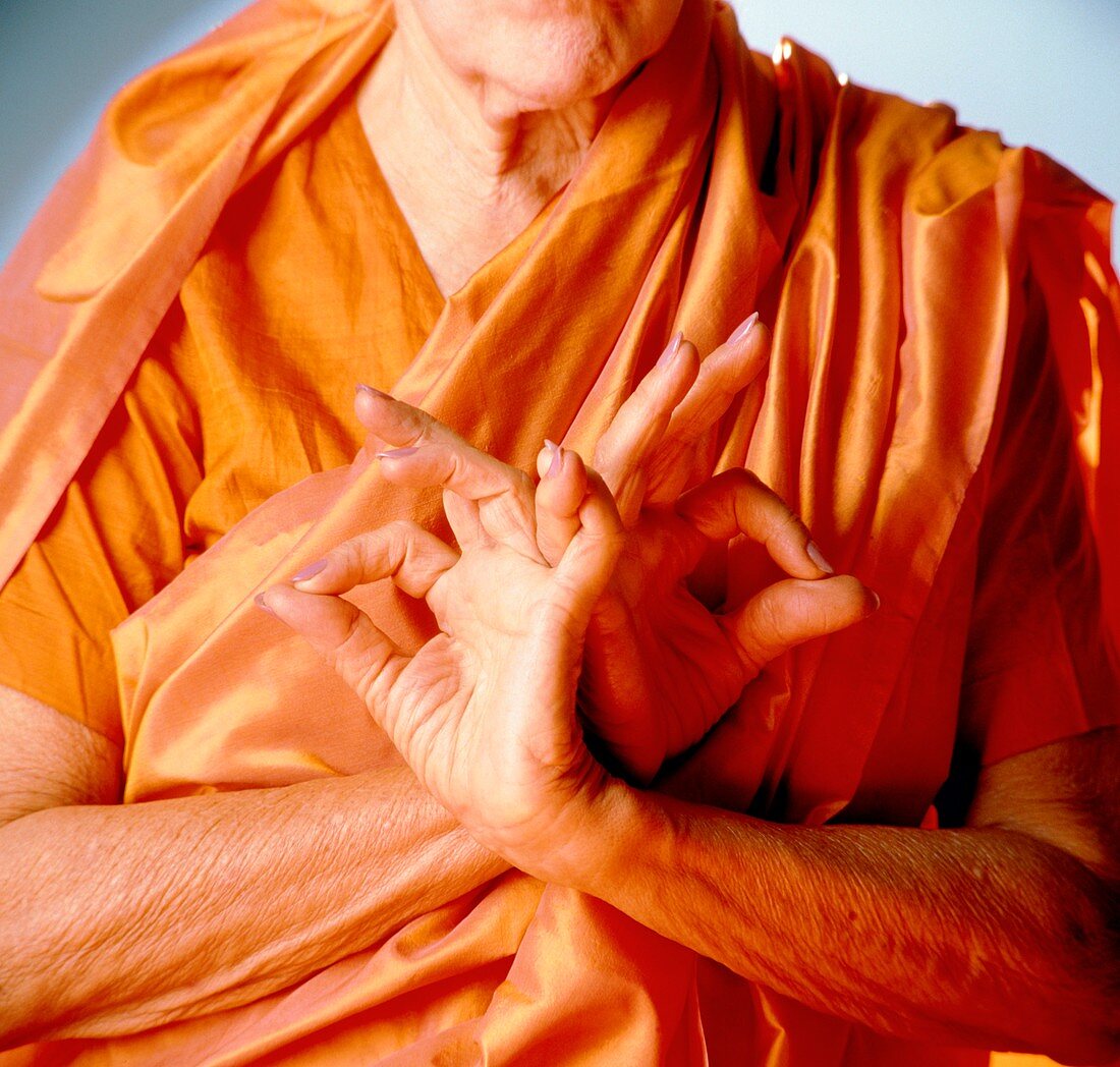 Woman wearing saffron robes in devotional pose
