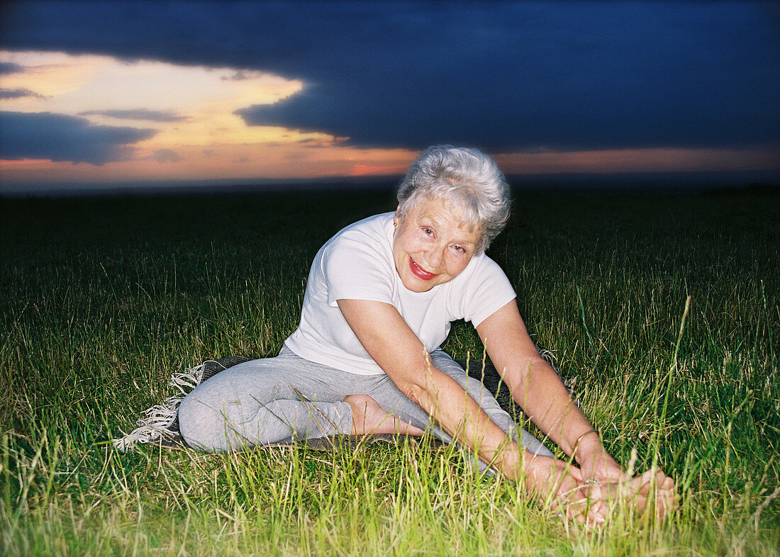 Elderly woman doing yoga exercises