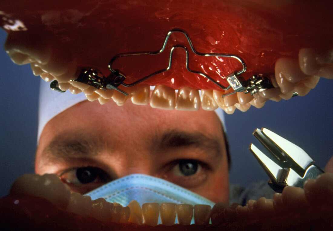 Dentist adjusting brace seen from inside the mouth