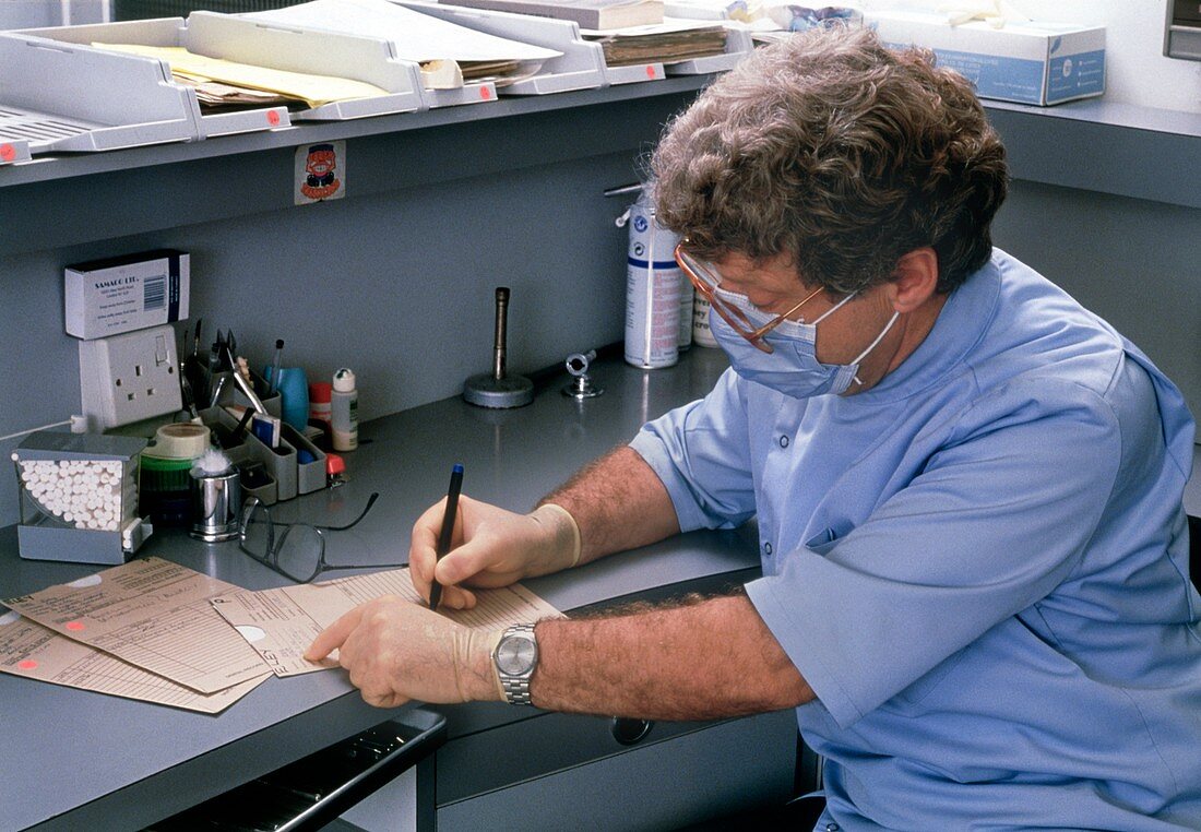 Dentist writing patient's notes